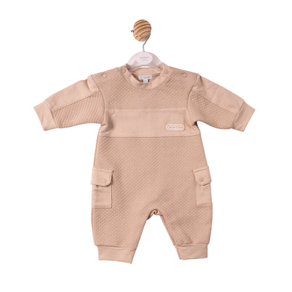 A baby's long-sleeve romper in a light beige color, featuring a textured honeycomb pattern on the chest and upper arms, a smooth solid fabric across the chest, and two front flap pockets.