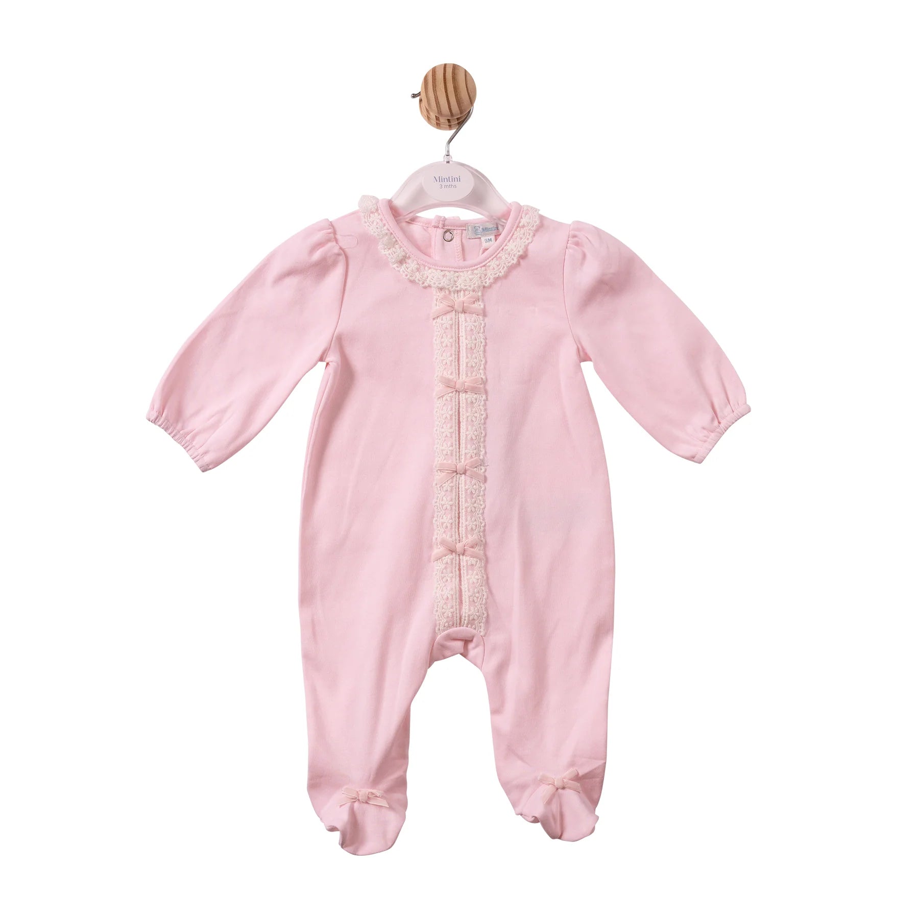 A light pink baby footed sleeper with long sleeves, a lace-trimmed round neckline, and decorative lace down the front